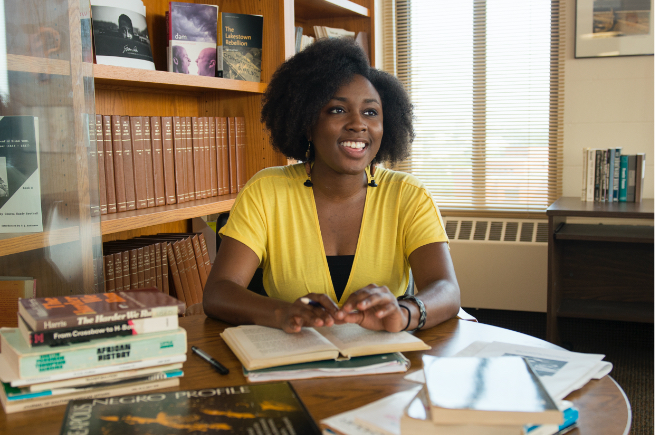 African-American female student working at desk in college office