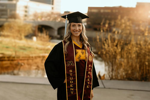 Kauryn Krier in cap and gown with a sash that says student athlete on campus