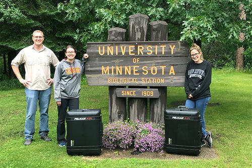 Peter Larsen, Kenwyn Shriner, and Laramie Lindsey alongside their mobile lab, which fits neatly into two suitcases.